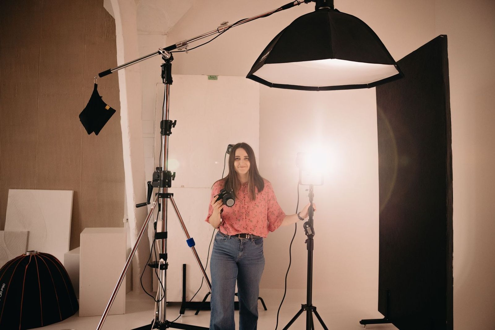 Fotografin mit Kamera im Studio mit Lichtanlage